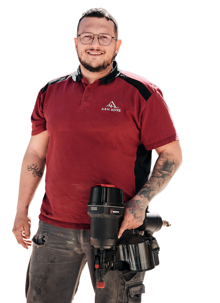 Handwerker mit Brille und Tätowierungen, trägt einen Druckluftnagler - bereit für Bauarbeiten.