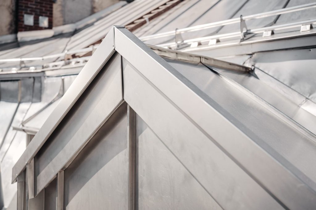 Detailaufnahme eines modernen Dachs mit metallischen Elementen und scharfen Kanten.